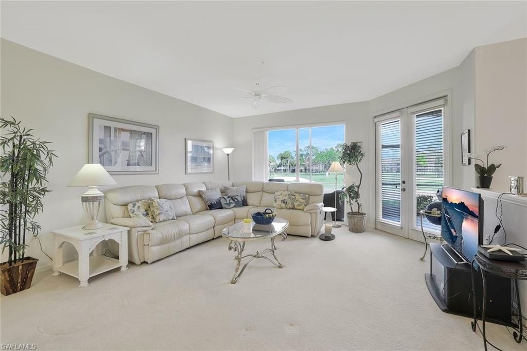Living area with light carpet, french doors, and a ceiling fan