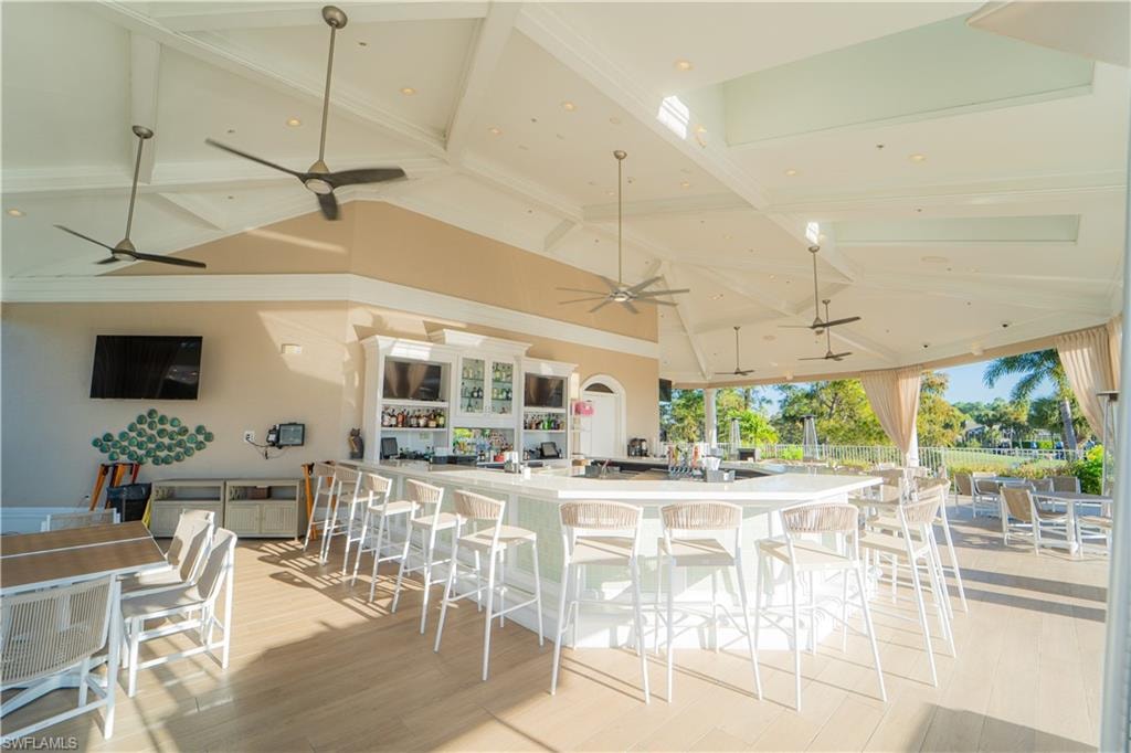Kitchen featuring a kitchen bar, a large island, vaulted ceiling, and recessed lighting