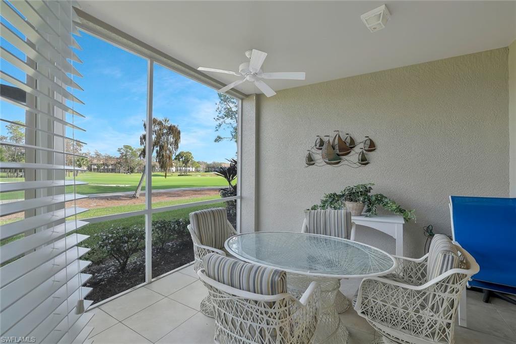 Sunroom featuring outdoor dining area, golf course view, and ceiling fan
