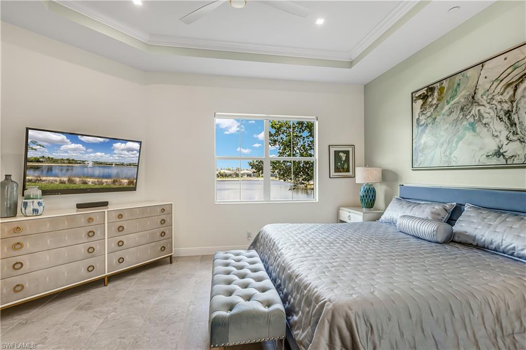 Bedroom featuring ornamental molding, a raised ceiling, and ceiling fan