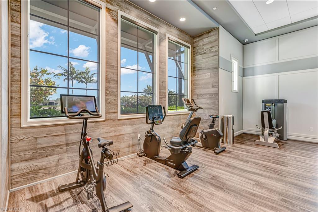 Workout area with light wood finished floors, a decorative wall, and wood walls