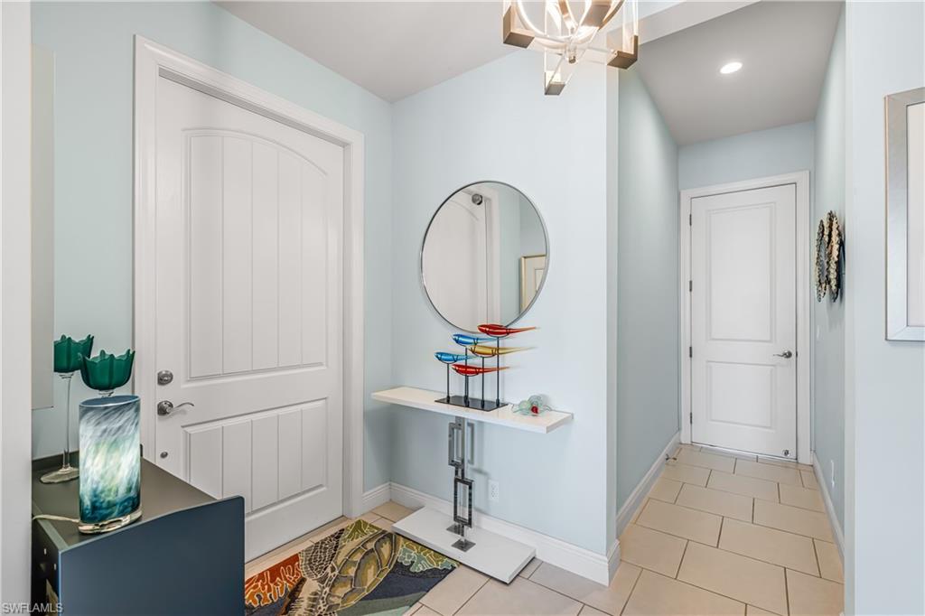 Entrance foyer with hanging lights and light tile patterned flooring