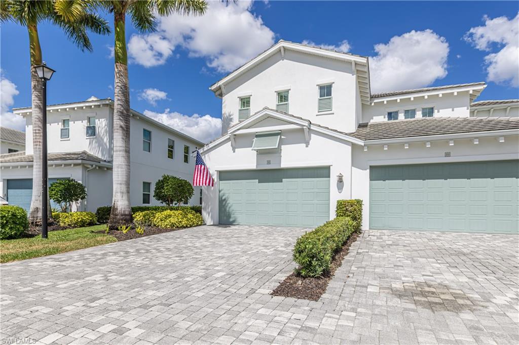 View of front of property with stucco siding, decorative driveway, a garage, and a tile roof