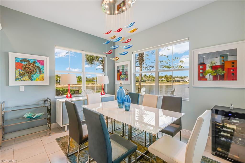 Dining space featuring healthy amount of natural light, a water view, and light tile patterned floors