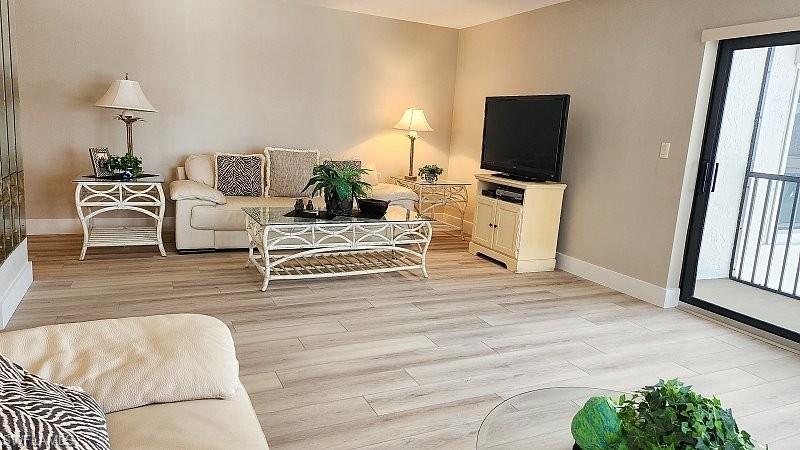 Living area featuring light wood-type flooring and baseboards