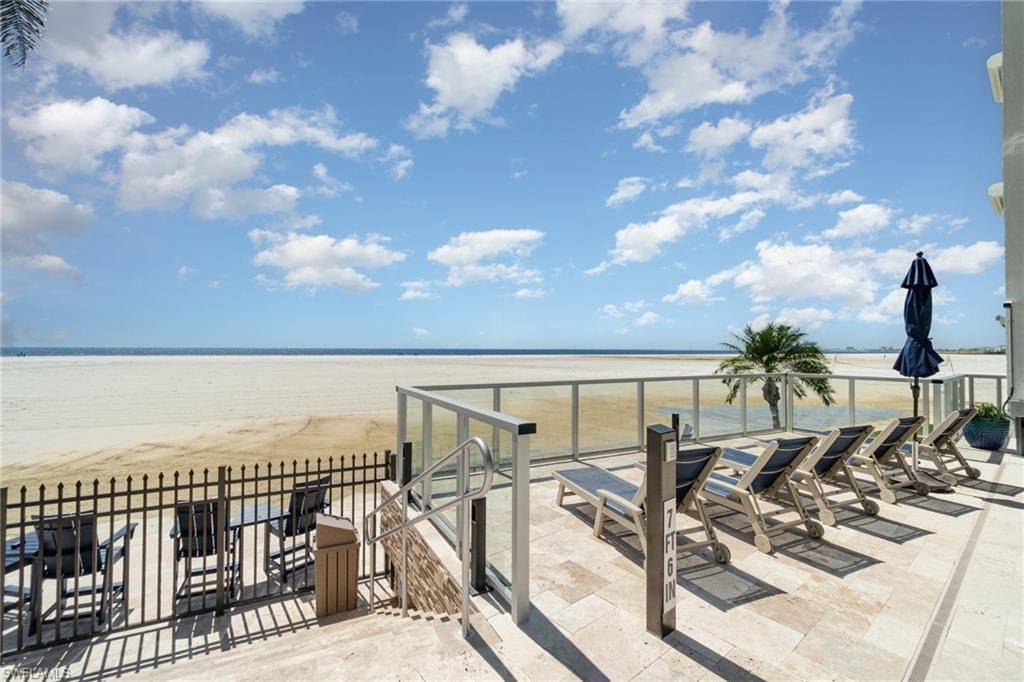 Elevated beachfront sundeck with panoramic Gulf views, featuring premium lounge seating and a glass railing that frames endless blue waters—an idyllic retreat for soaking in sunshine and coastal serenity.