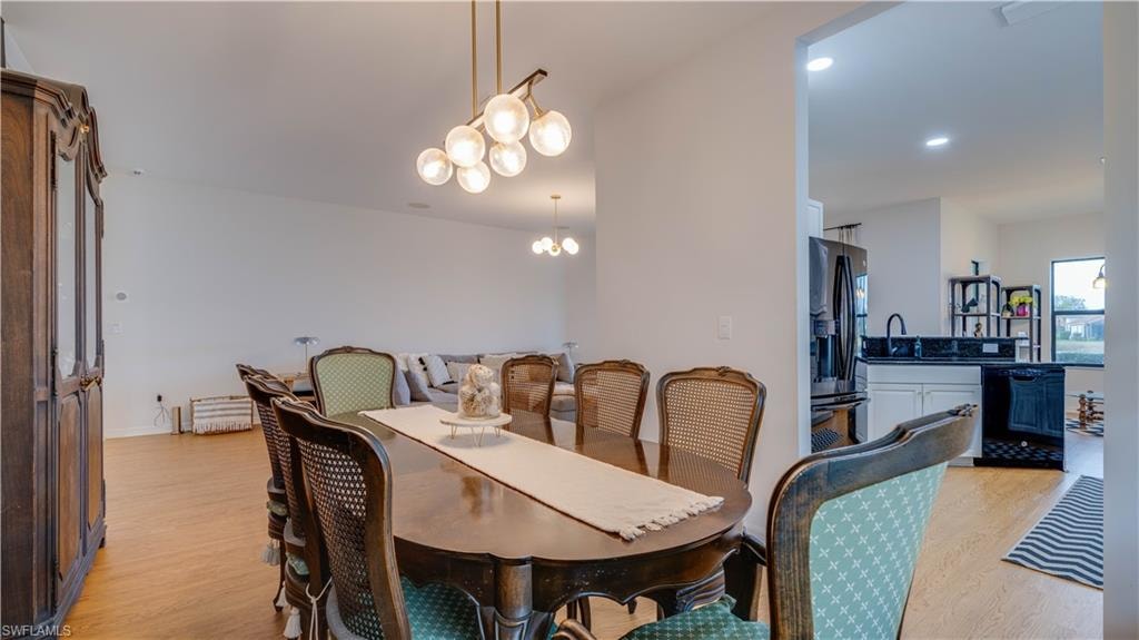Dining space with light wood-style flooring and hanging lights