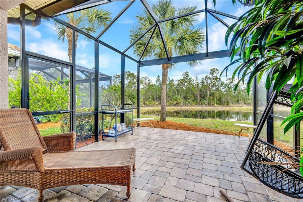 Sunroom featuring a water view and a patio