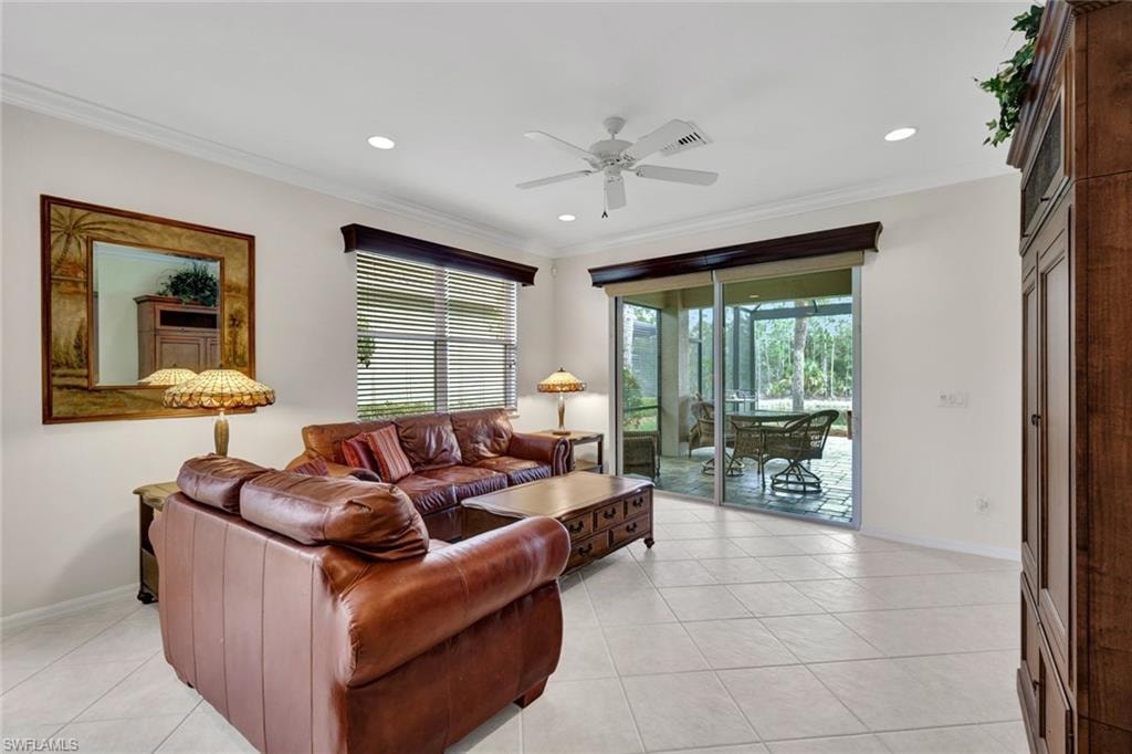Living area with a ceiling fan, light tile patterned flooring, healthy amount of natural light, ornamental molding, and recessed lighting