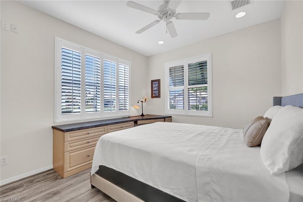 Bedroom featuring light wood-style floors, a ceiling fan, and recessed lighting