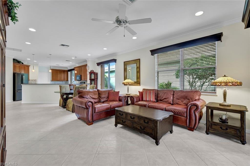 Living area featuring a ceiling fan, recessed lighting, ornamental molding, and light tile patterned floors
