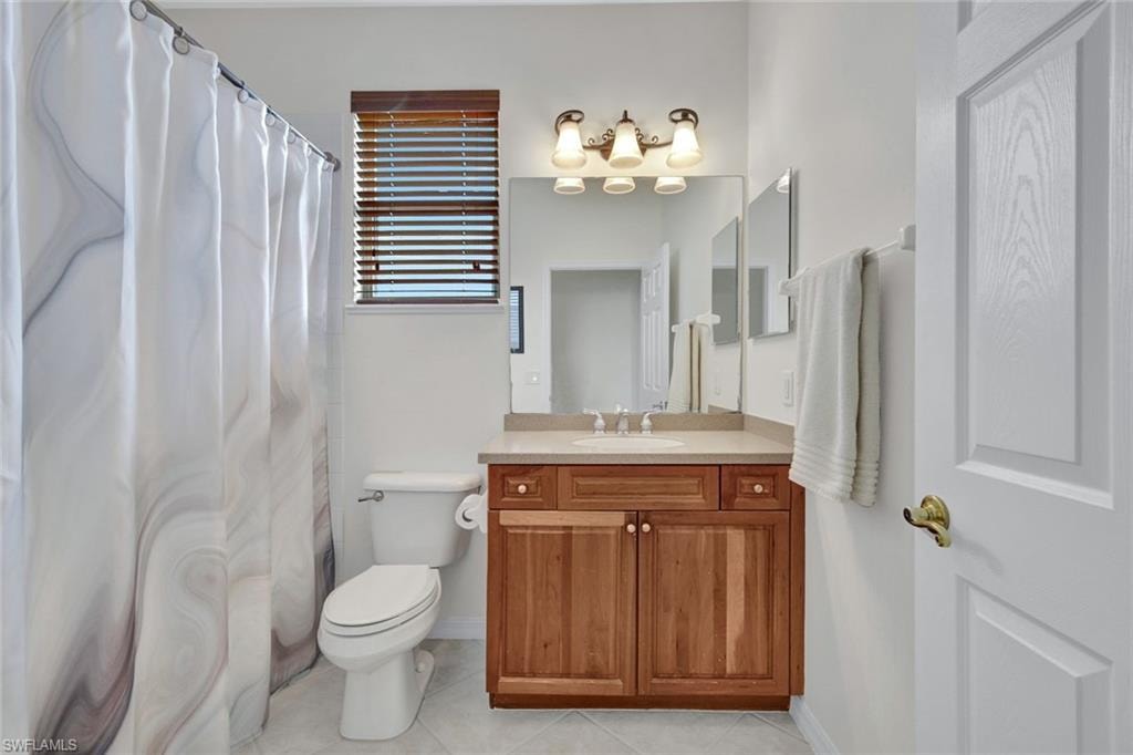 Bathroom featuring vanity, curtained shower, and light tile patterned floors