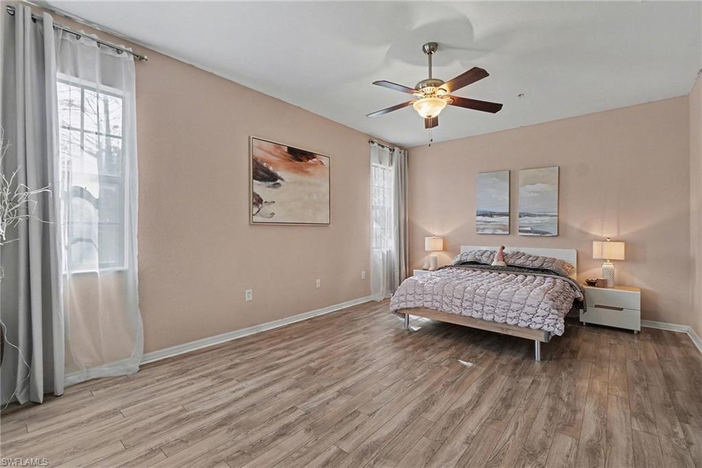 Primary bedroom featuring light wood-type flooring and ceiling fan