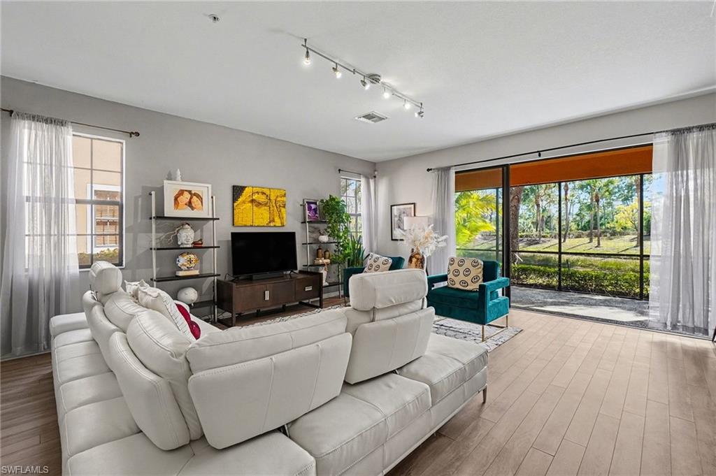 Living room featuring wood finished floors, plenty of natural light, and rail lighting