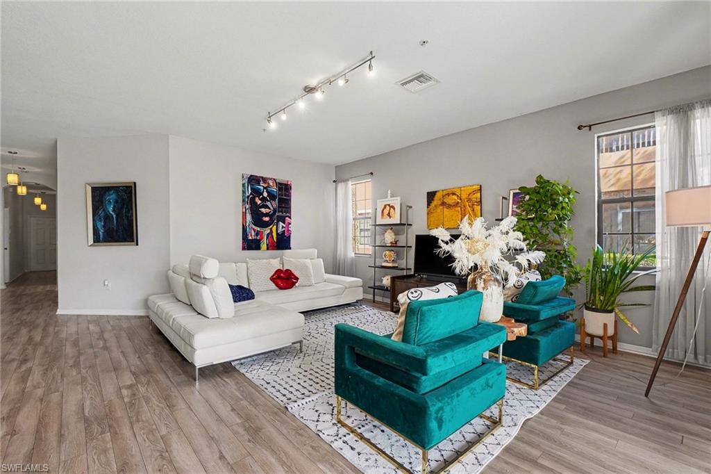 Living area featuring light wood finished floors and rail lighting