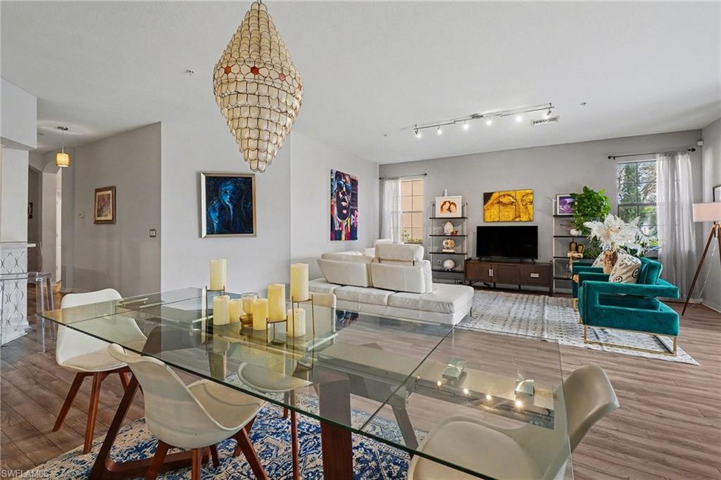Dining space featuring wood finished floors, healthy amount of natural light, and suspended lighting