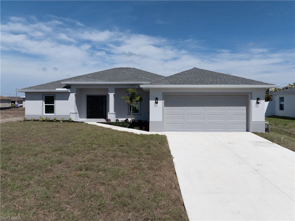 View of front of house featuring a front yard, stucco siding, concrete driveway, a shingled roof, and an attached garage