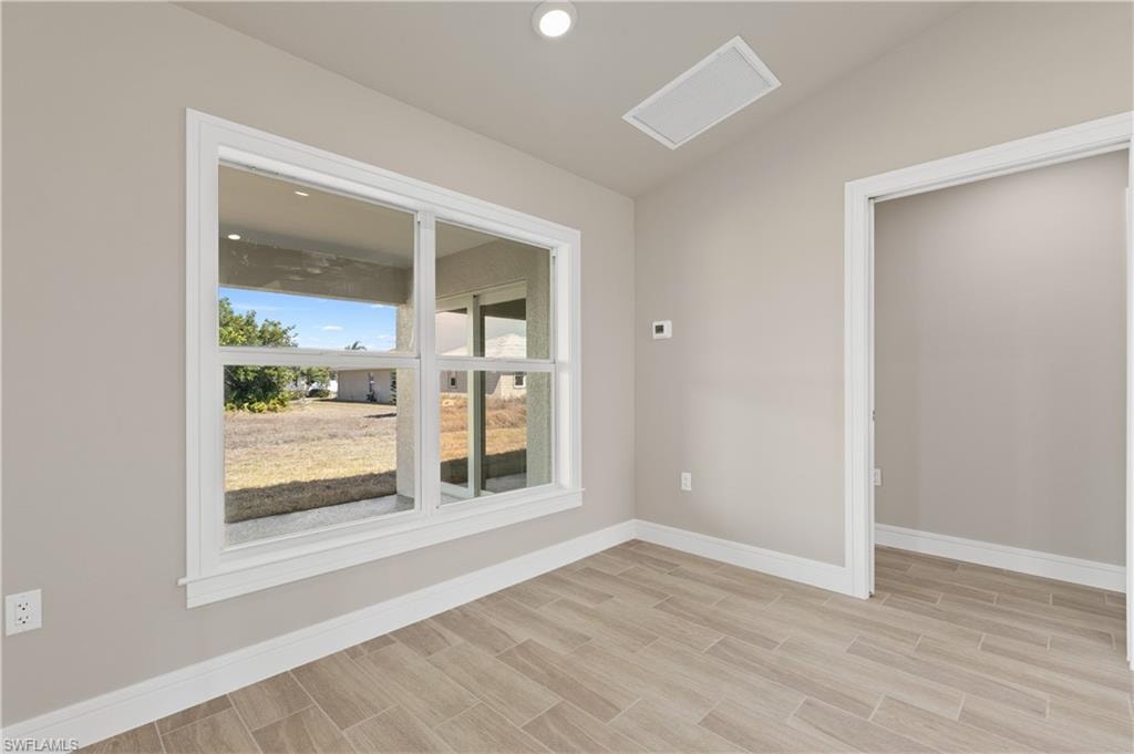 Spare room featuring lofted ceiling, wood finish floors, and recessed lighting