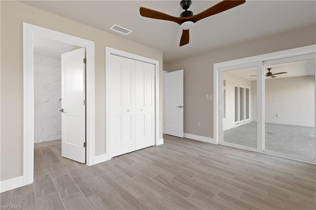 Unfurnished bedroom with wood tiled floors, a closet, a ceiling fan, and access to exterior