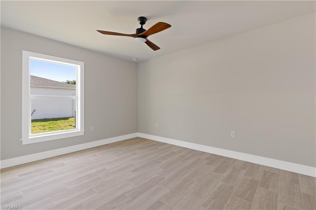 Unfurnished room featuring ceiling fan and wood tiled floors