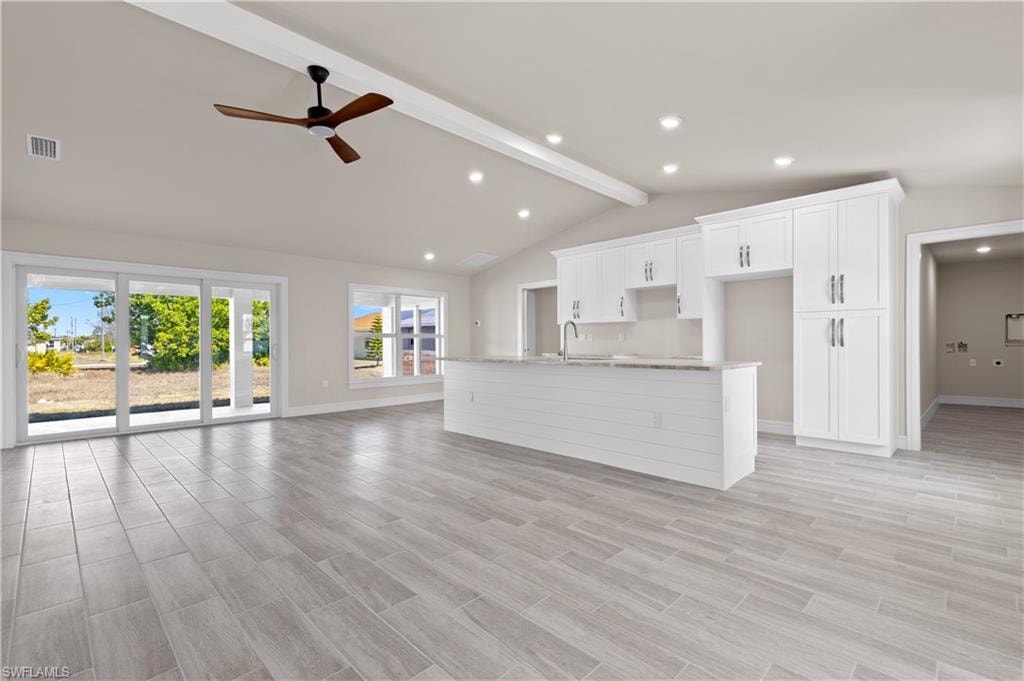 Unfurnished living room featuring wood tiled floors, ceiling fan, and recessed lighting