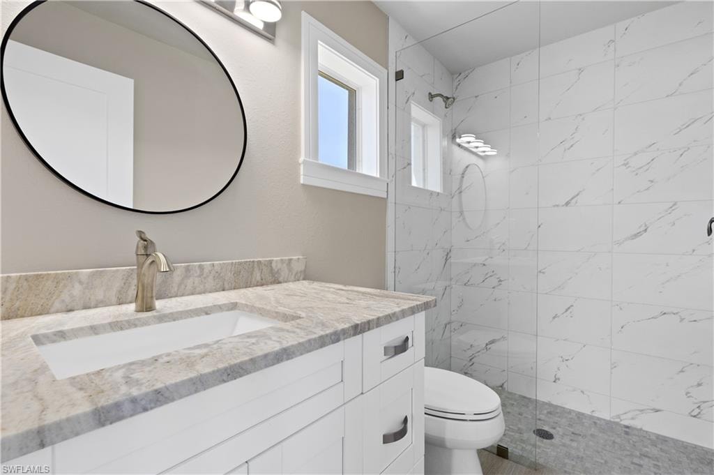 Full bathroom with a marble finish shower and vanity