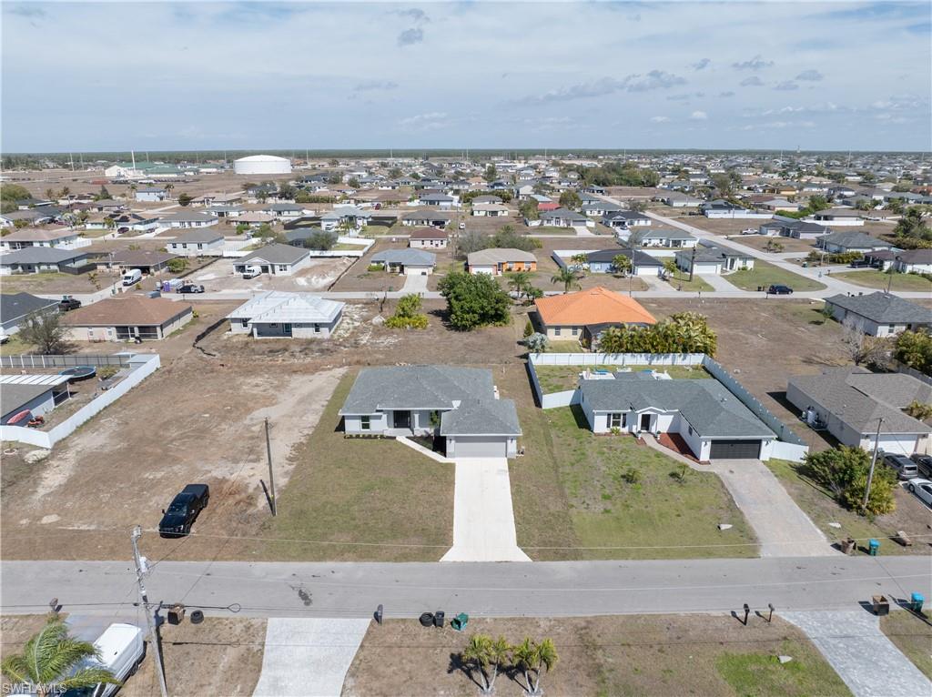 Aerial view of property and surrounding area featuring nearby suburban area