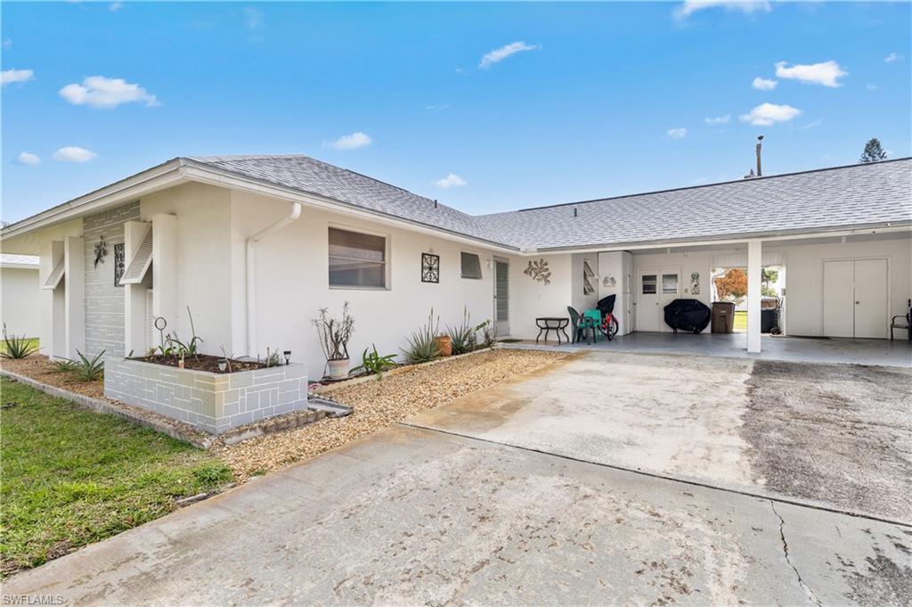 Single story home featuring a shingled roof, stucco siding, a patio, and driveway