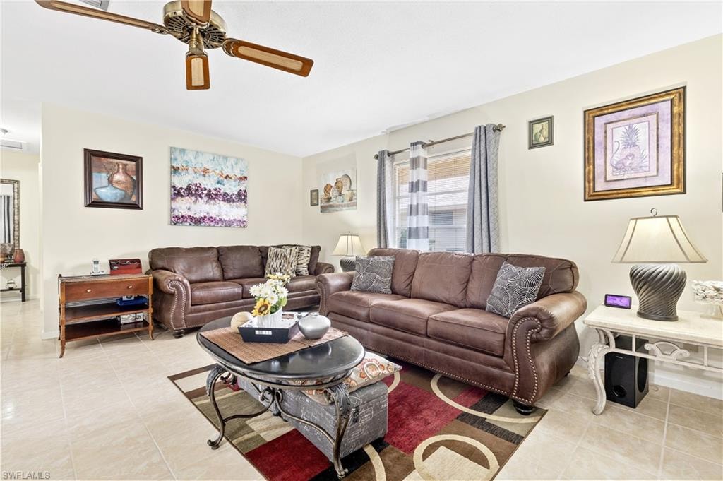 Living area featuring a ceiling fan and light tile patterned floors