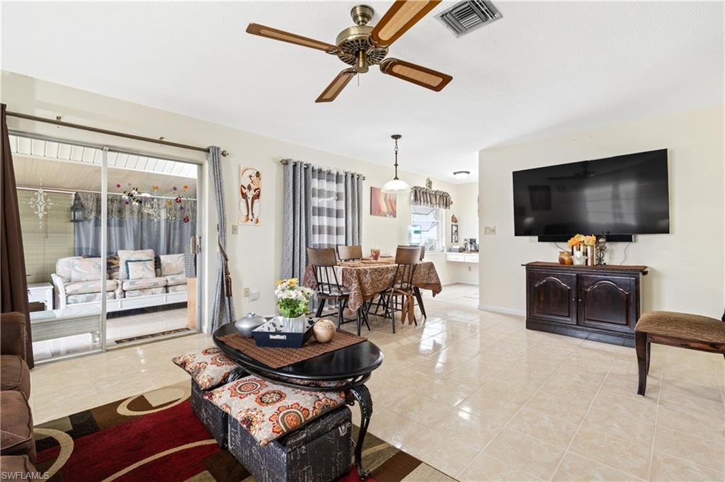 Living area featuring ceiling fan and light tile patterned floors