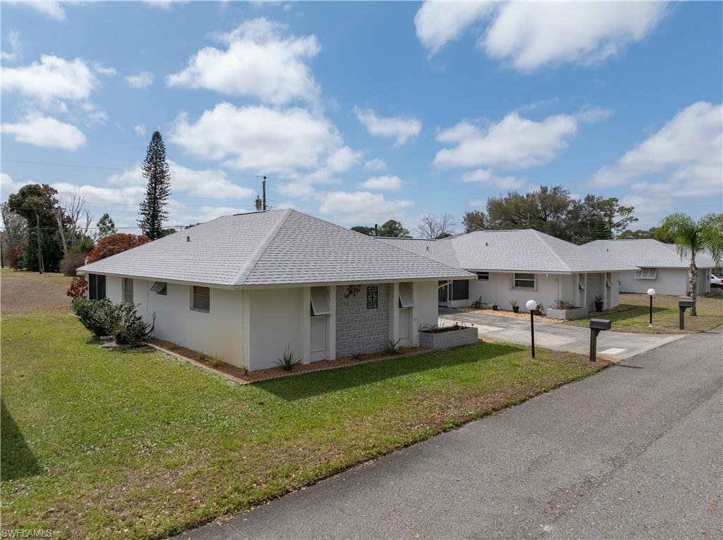 Ranch-style home with a front yard and a shingled roof