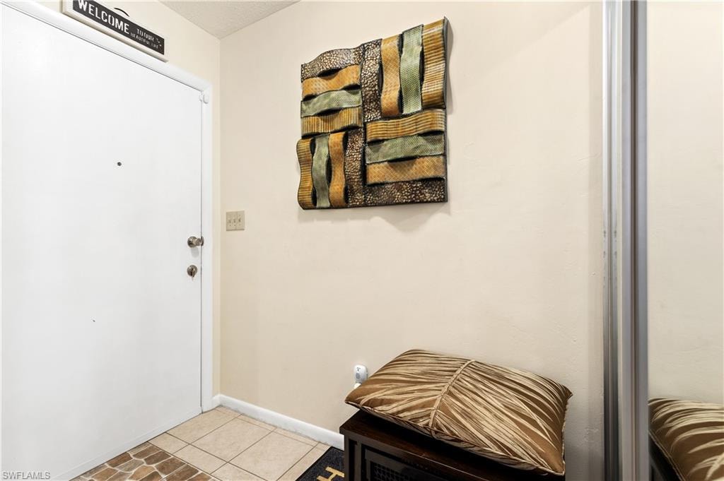Entryway with baseboards and tile patterned flooring