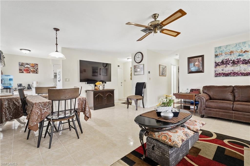 Living room featuring a ceiling fan and light tile patterned floors