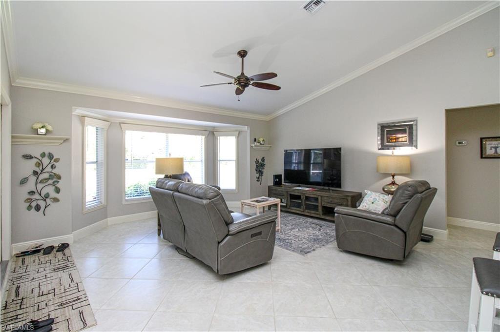 Living area with vaulted ceiling, ornamental molding, visible vents, and ceiling fan