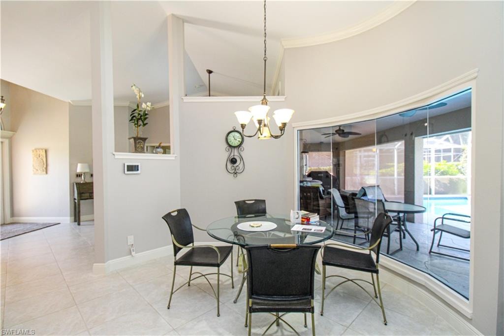 Dining area featuring tile patterned flooring, an inviting chandelier, and baseboards