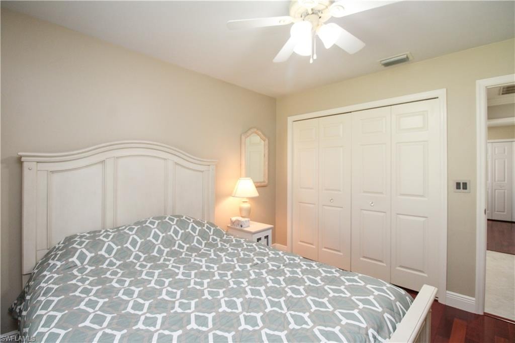 Bedroom with visible vents, a closet, baseboards, ceiling fan, and dark wood-style flooring