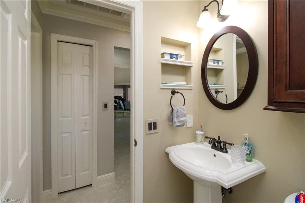 Bathroom with built in features, a closet, a sink, and tile patterned flooring