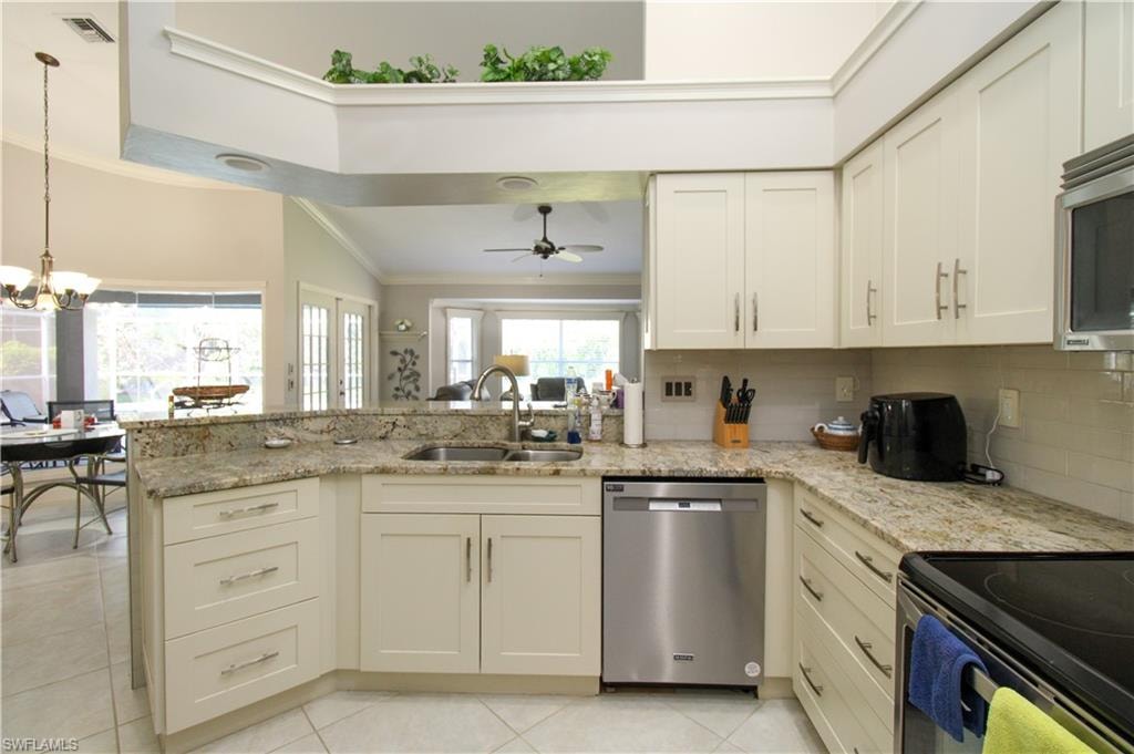 Kitchen featuring visible vents, a peninsula, a sink, stainless steel appliances, and crown molding