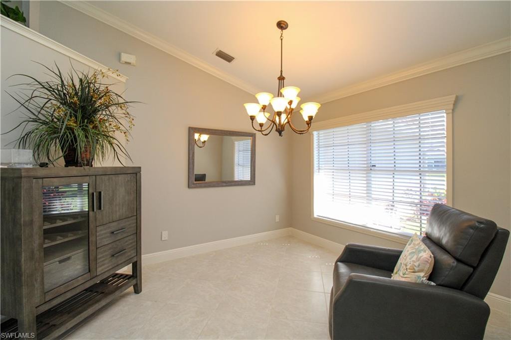 Sitting room featuring visible vents, lofted ceiling, a notable chandelier, and ornamental molding