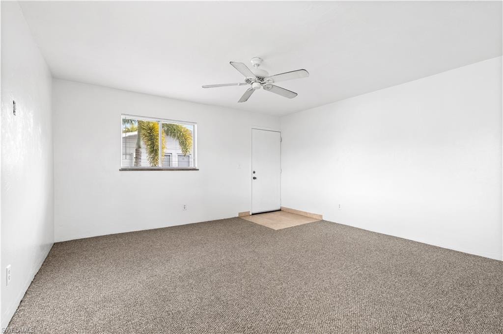 Carpeted spare room with ceiling fan