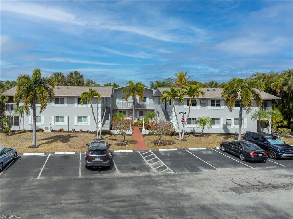 View of apartment building / complex featuring uncovered parking