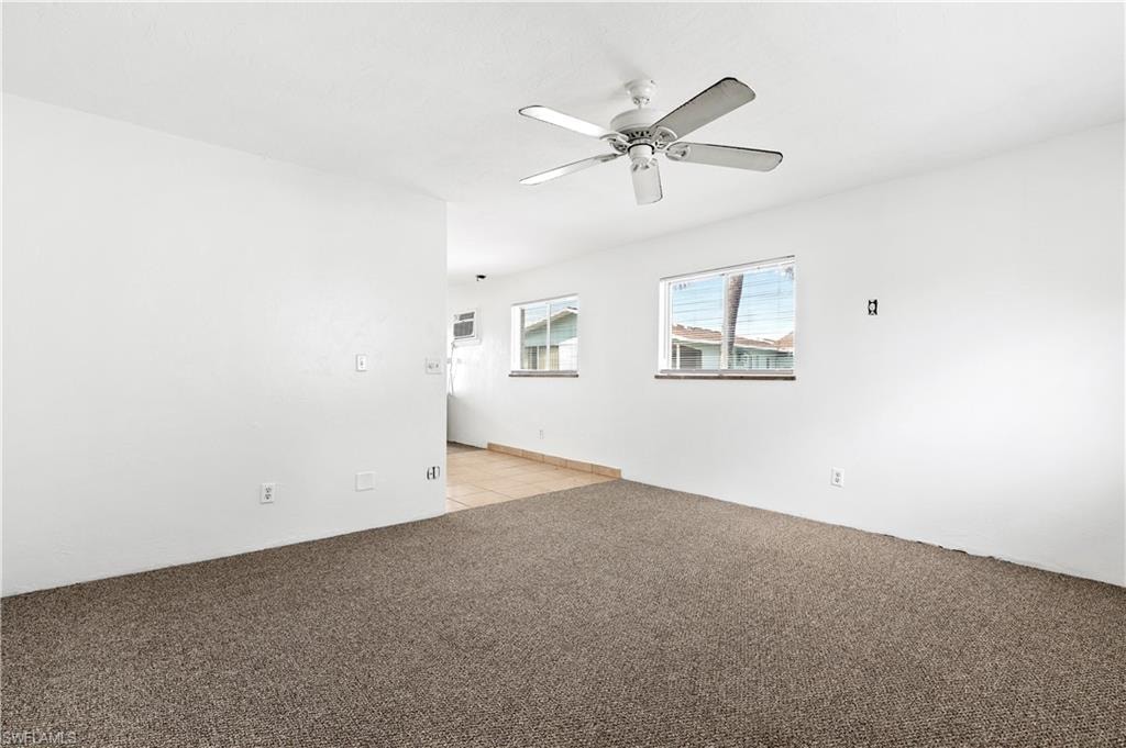 Unfurnished room with a ceiling fan and light carpet