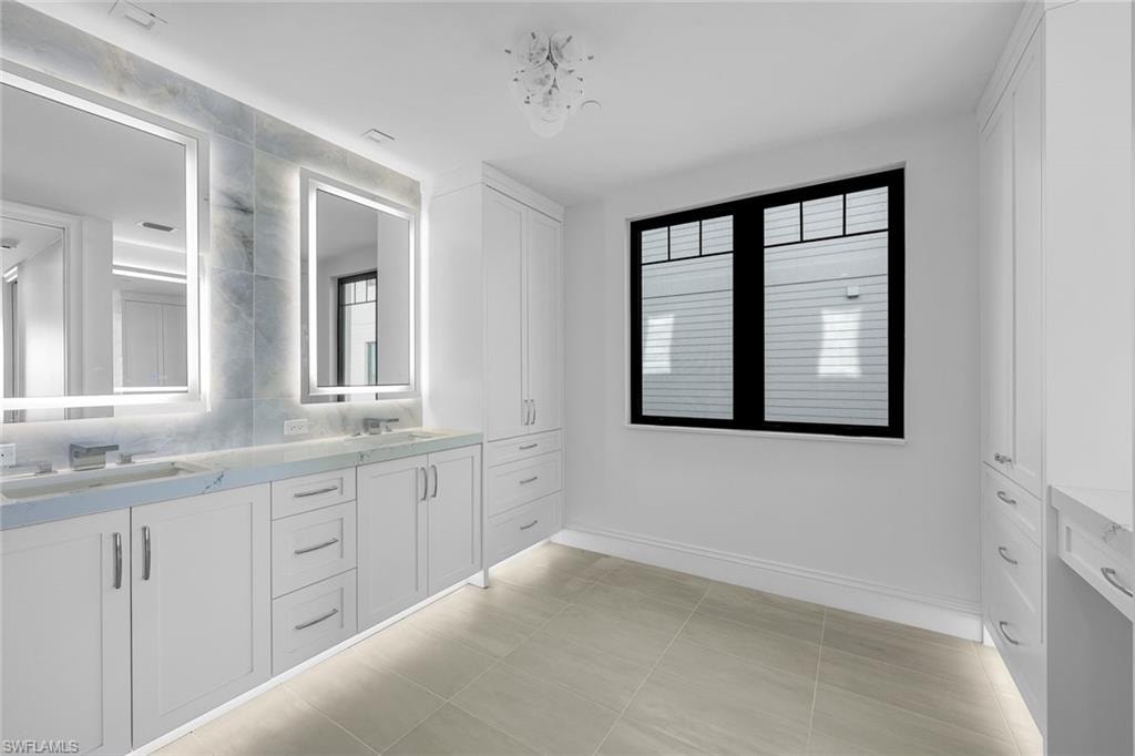 Bathroom featuring double vanity and light tile patterned floors