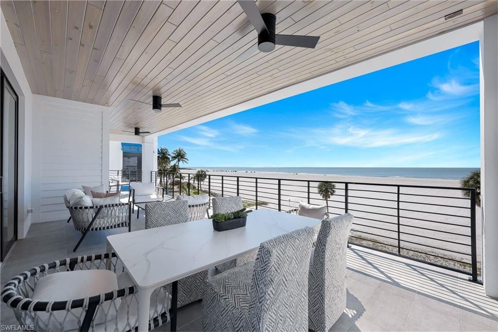 Balcony with ceiling fan, outdoor lounge area, and view of water and beach