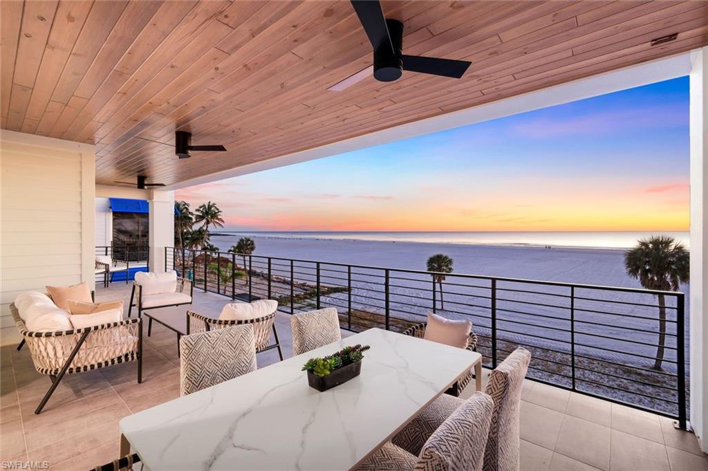 Patio terrace at dusk featuring a ceiling fan, a patio area, outdoor lounge area, and a water view
