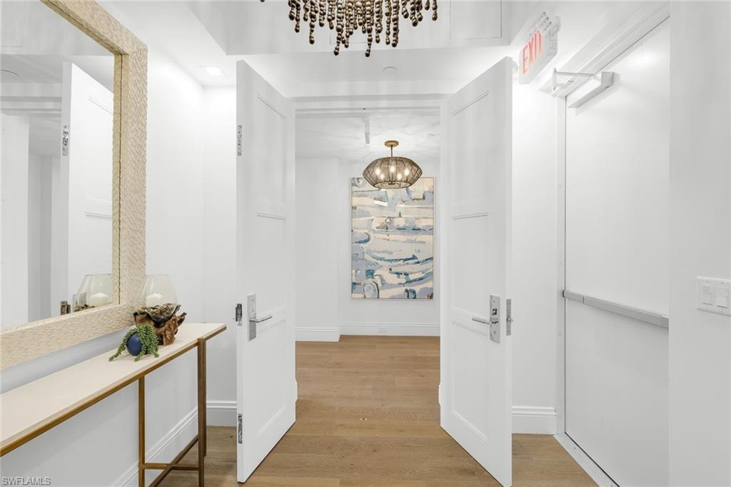 Corridor with hanging lights and light wood finished floors