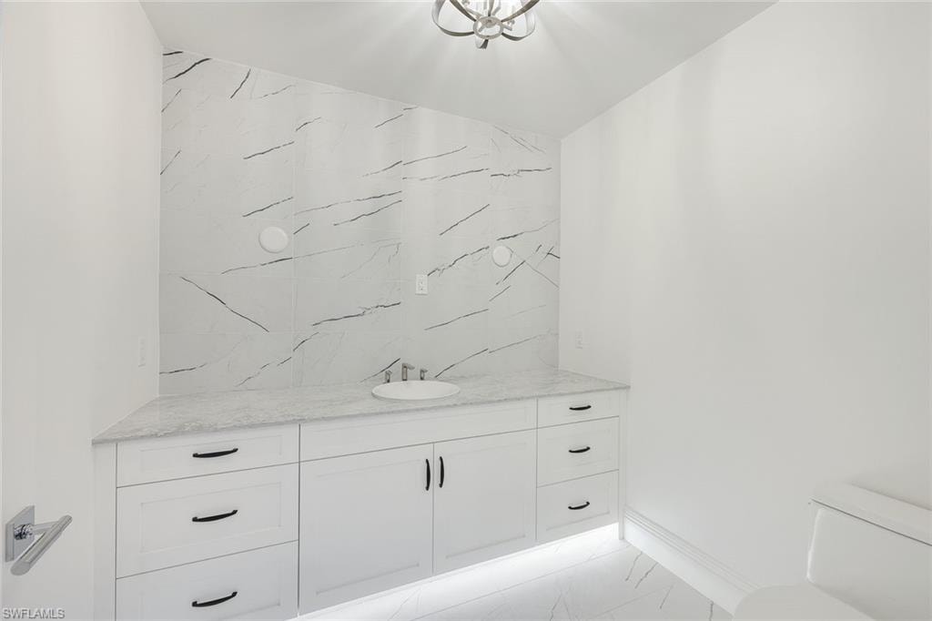 Bathroom featuring vanity and light marble finish flooring