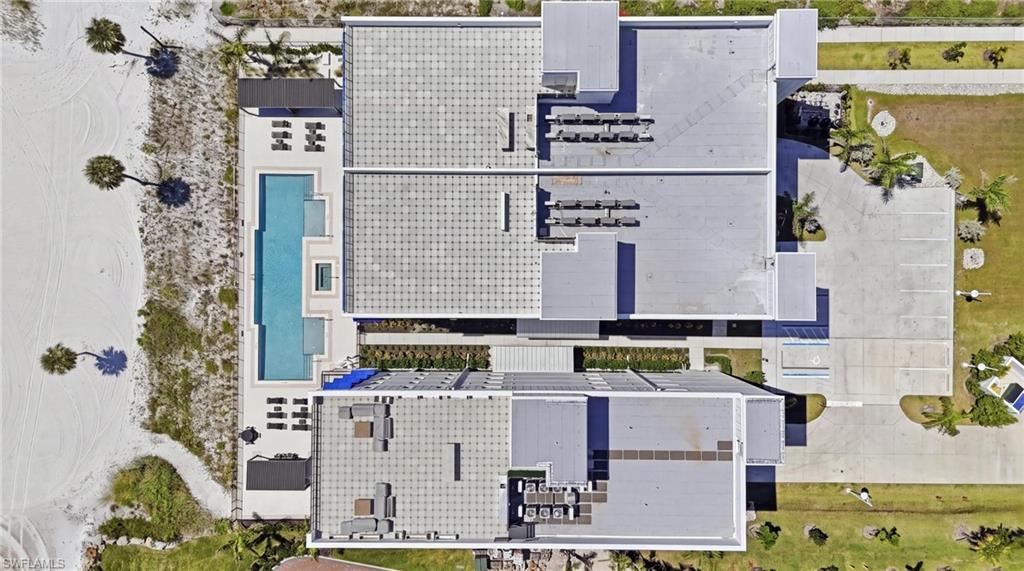 Expansive outdoor pool deck with a rectangular pool, spa, and multiple seating areas - Virtually Edited Image