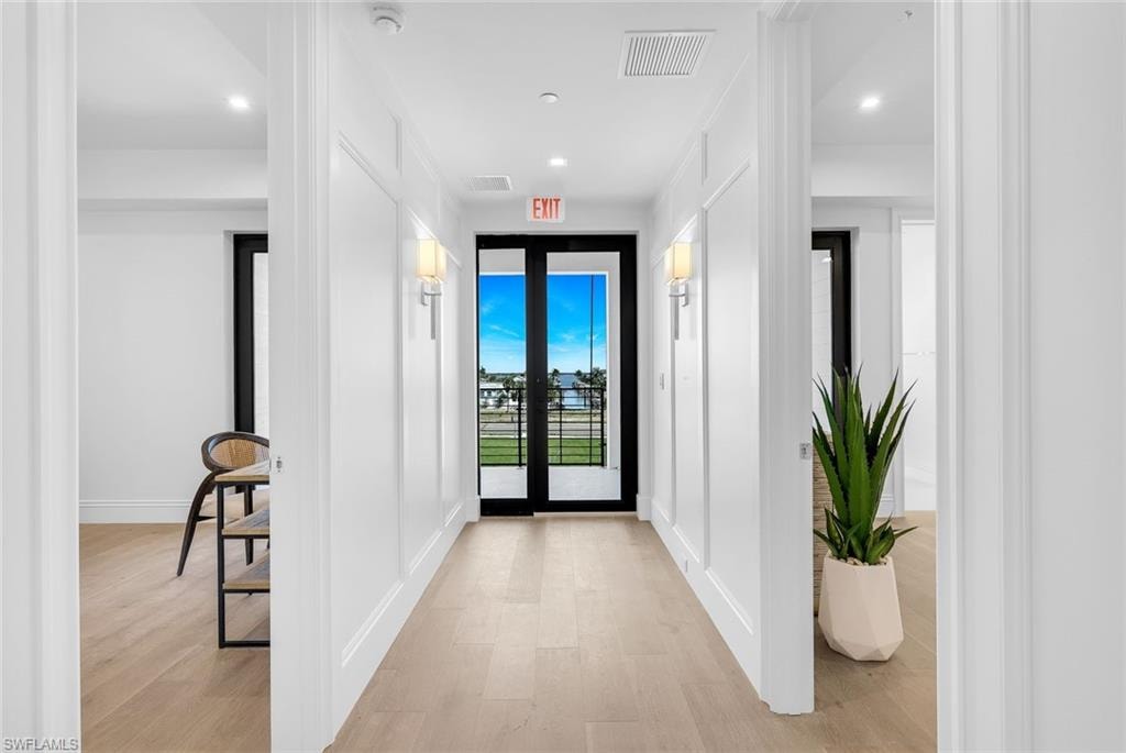 Foyer entrance with french doors, light wood-style flooring, and recessed lighting