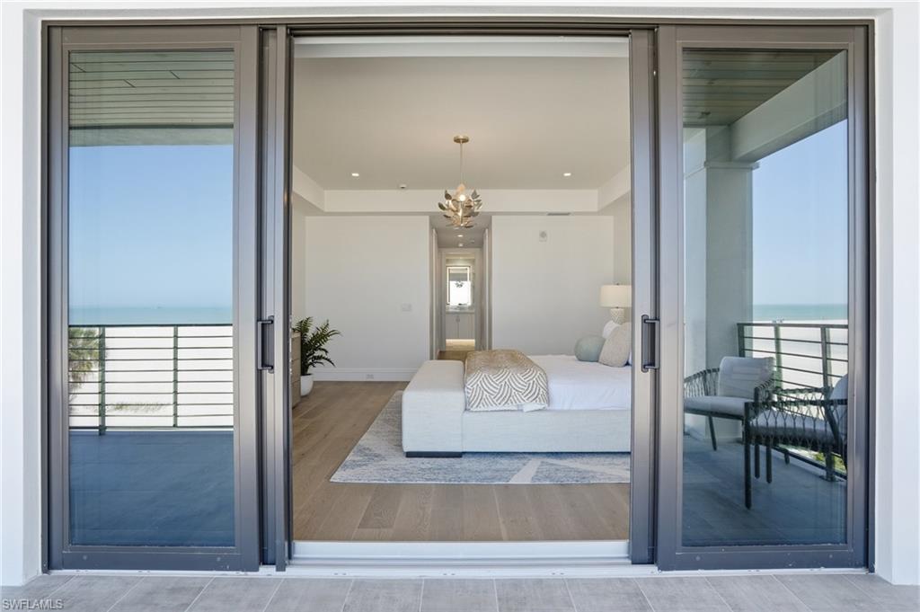 Bedroom with a water view, access to exterior, and a chandelier